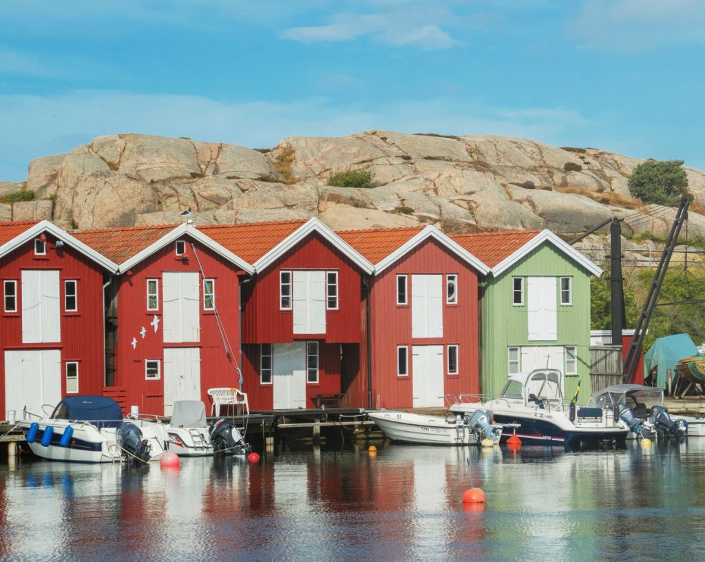 Motorbåtar vid ett gammalt fiskeläge med nyrenoverade fiskebodar.