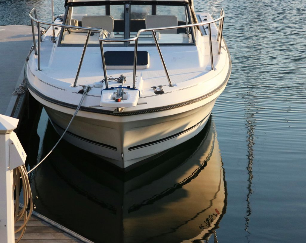 Motorbåt som ligger förtöjd vid brygga.