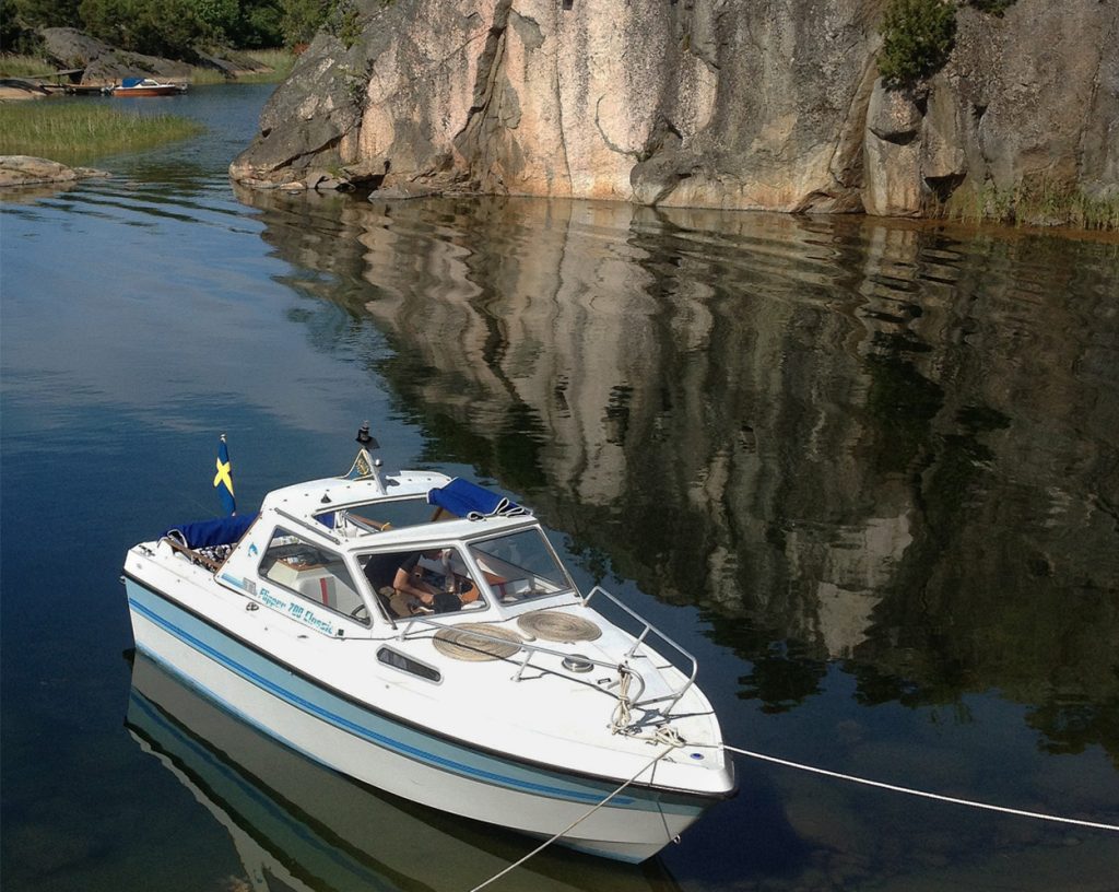 En båt ligger förtöjd vid en ö i Stockholms skärgård.