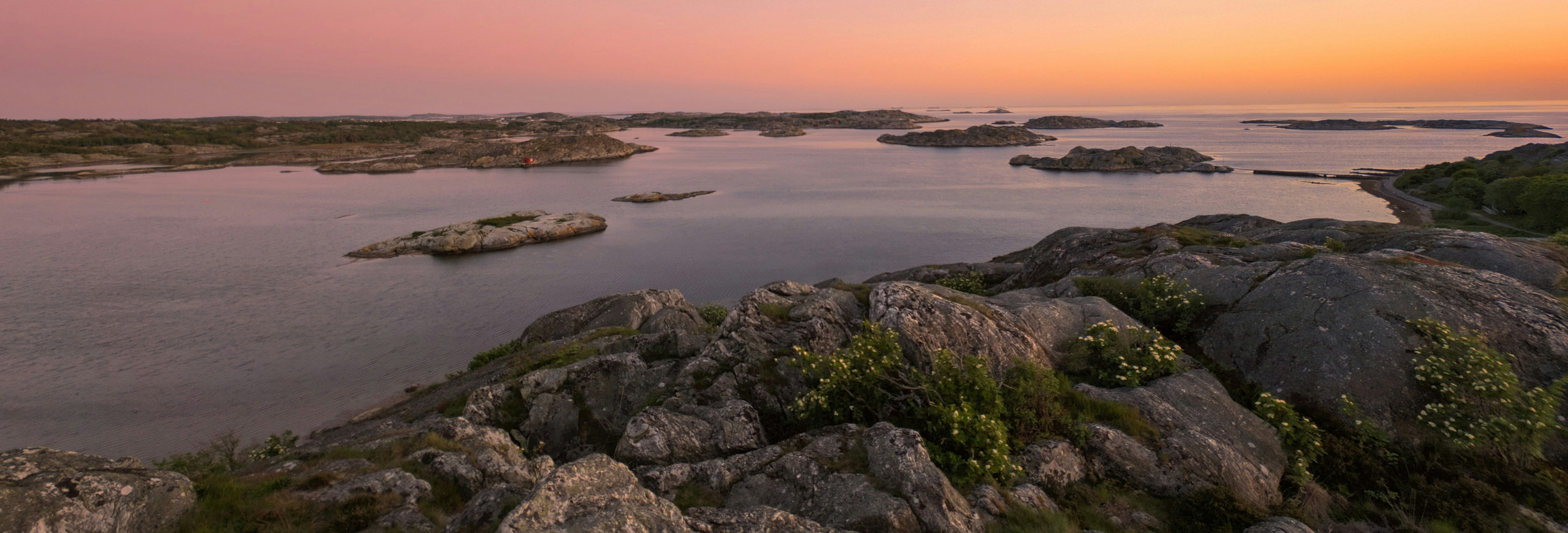 Vy över svenska skärgården i gyllene timmens ljus.